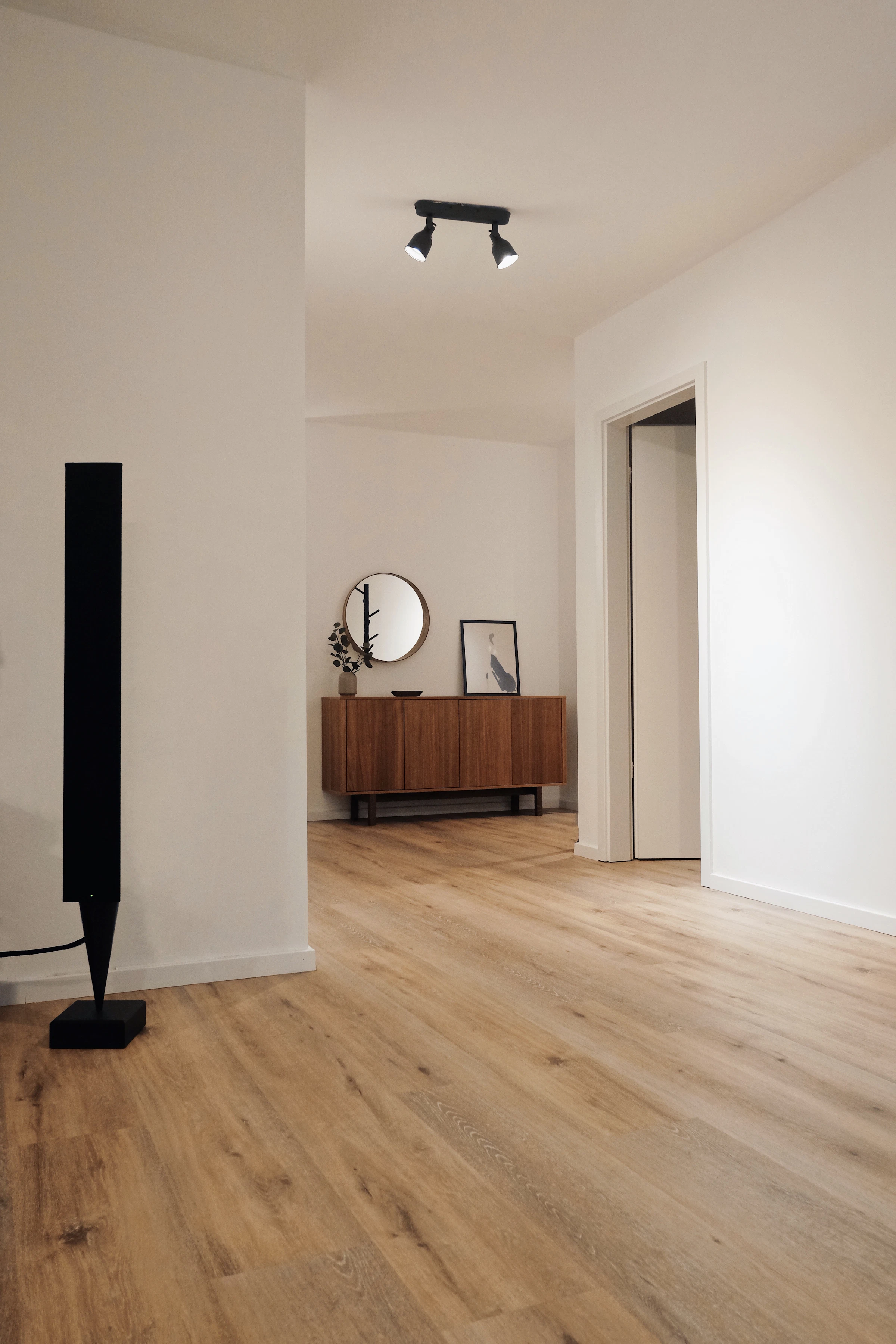 Empty room with wooden flooring and white walls, ready for fit-out