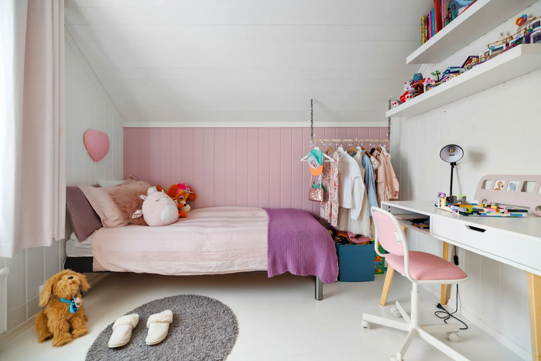 Child's bedroom with a single bed, a study desk under the window and open shelves