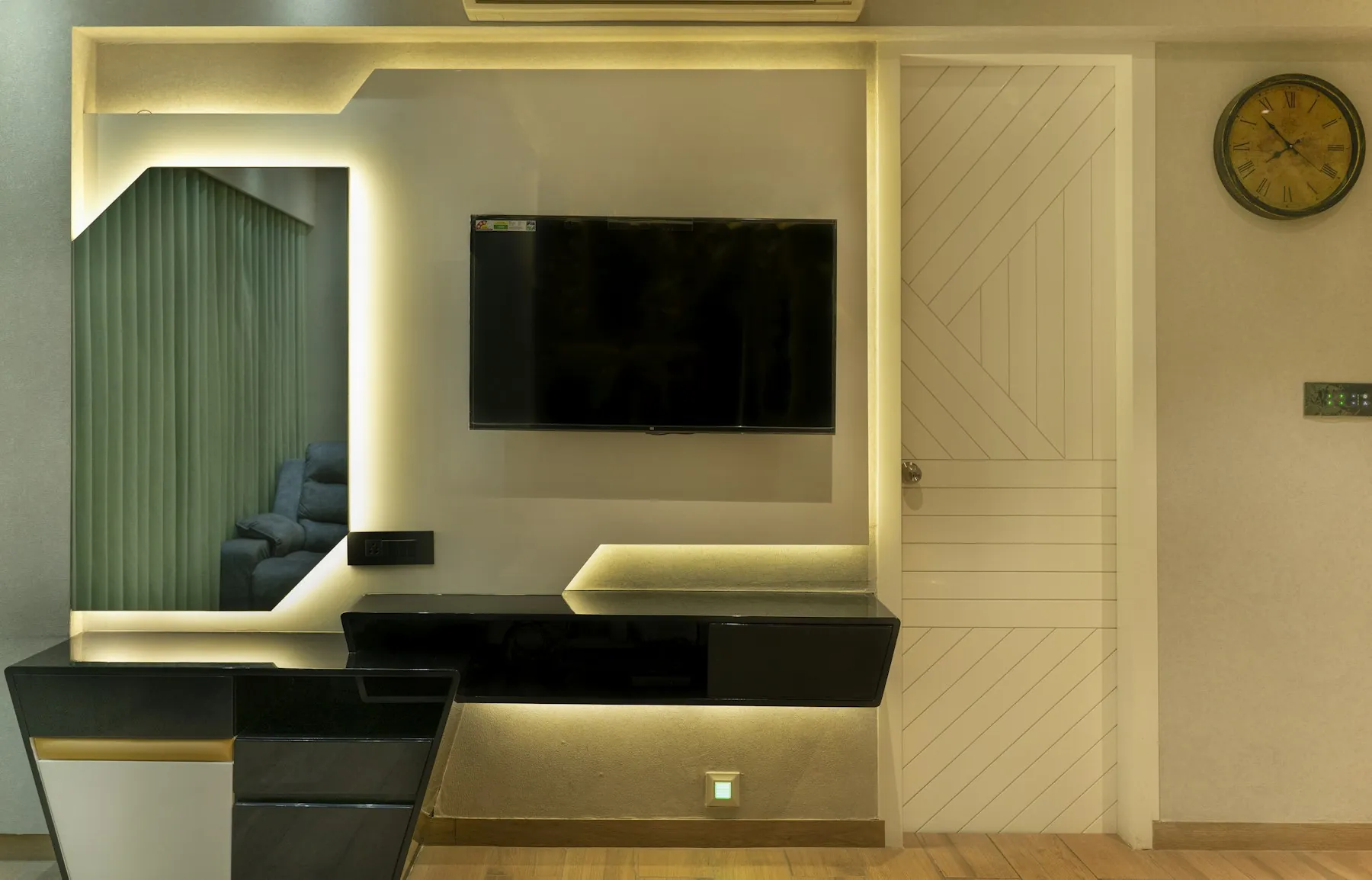 TV wall with a backlit panel, a floating console and a patterned door beside it