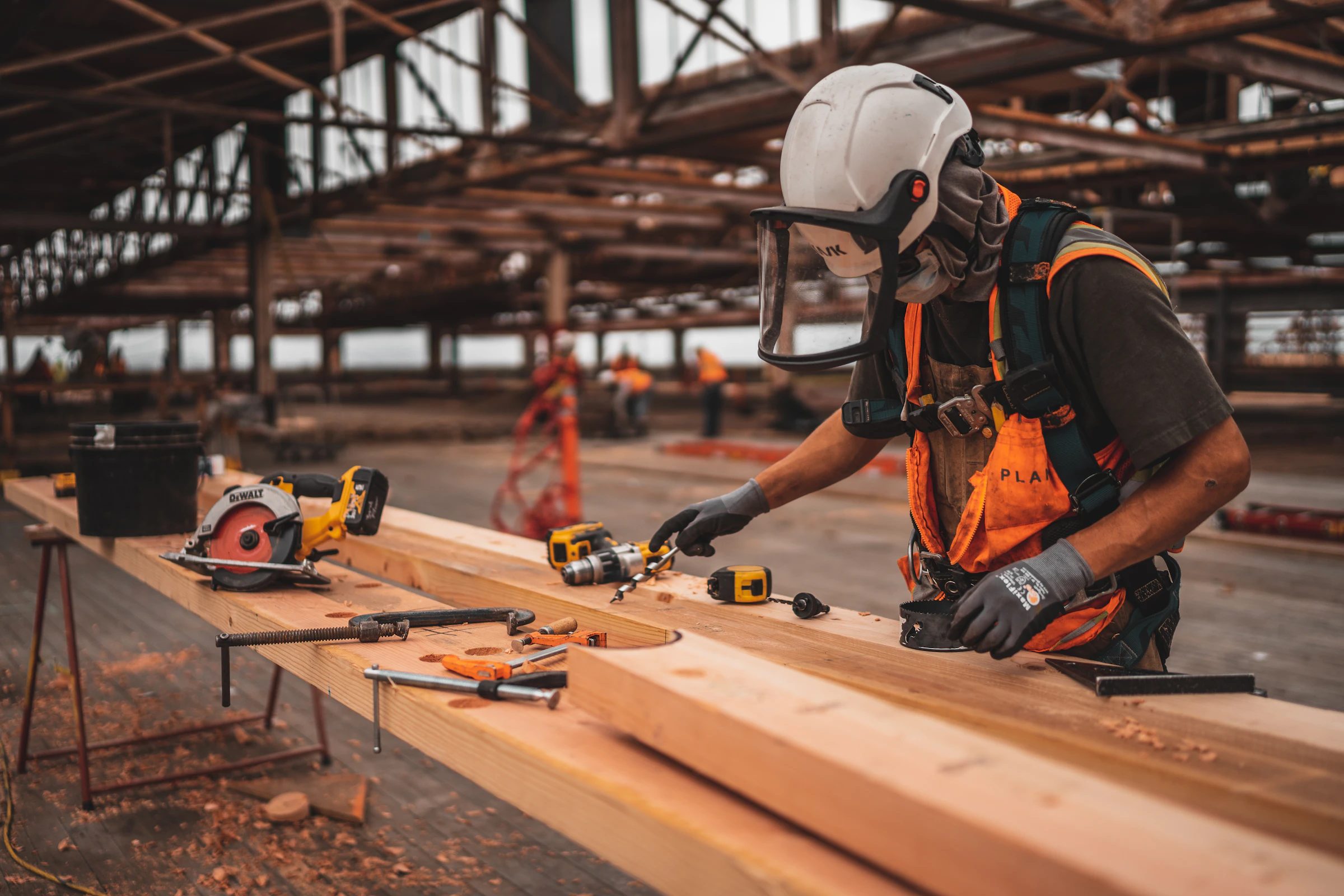 Carpenter cutting timber with power tools in a workshop